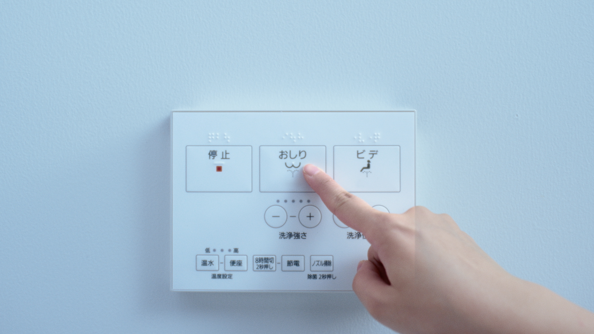 操作パネルで温水の位置や水勢を調整している様子